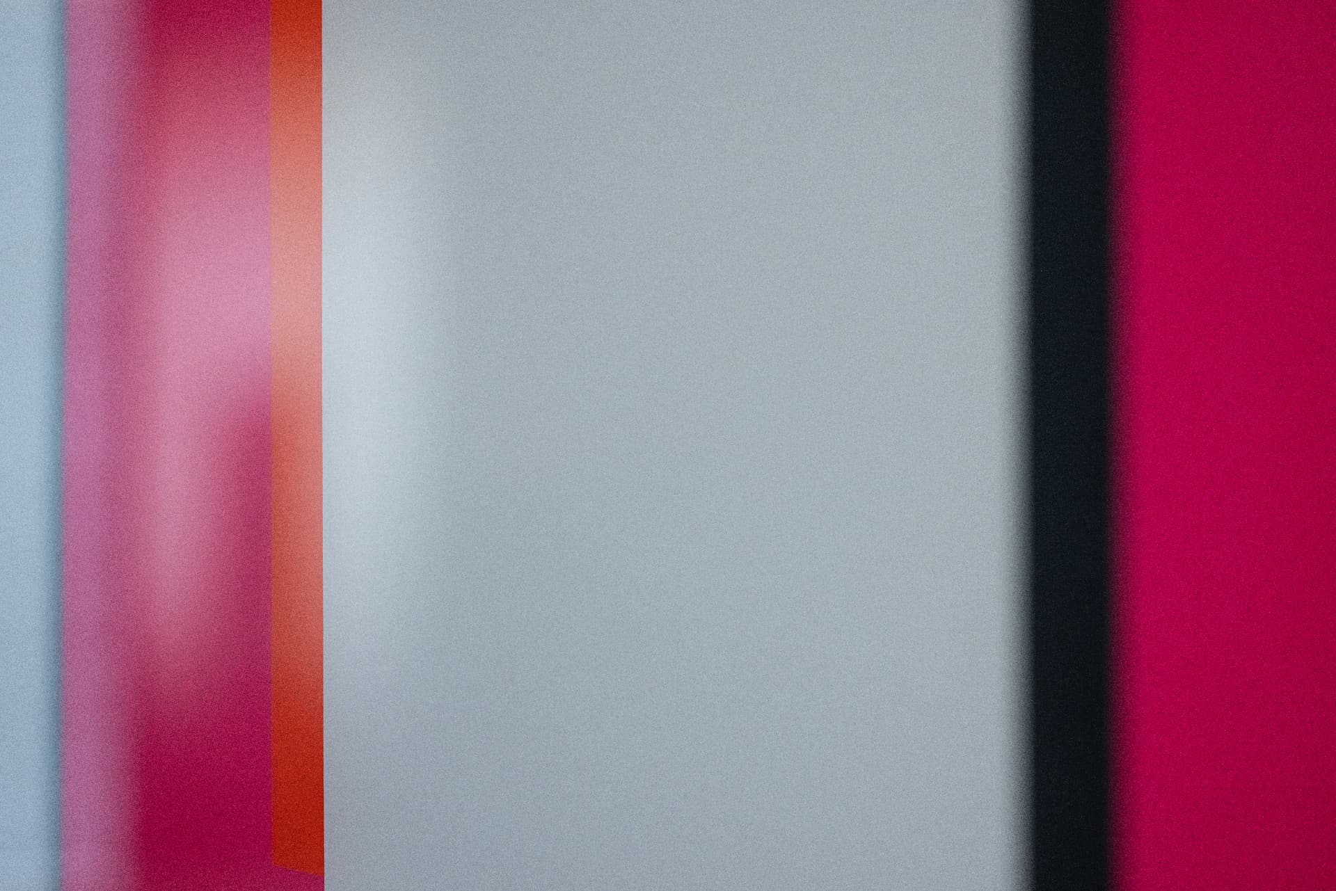 Abstract colour fields in pink, grey and crimson from a lounge interior