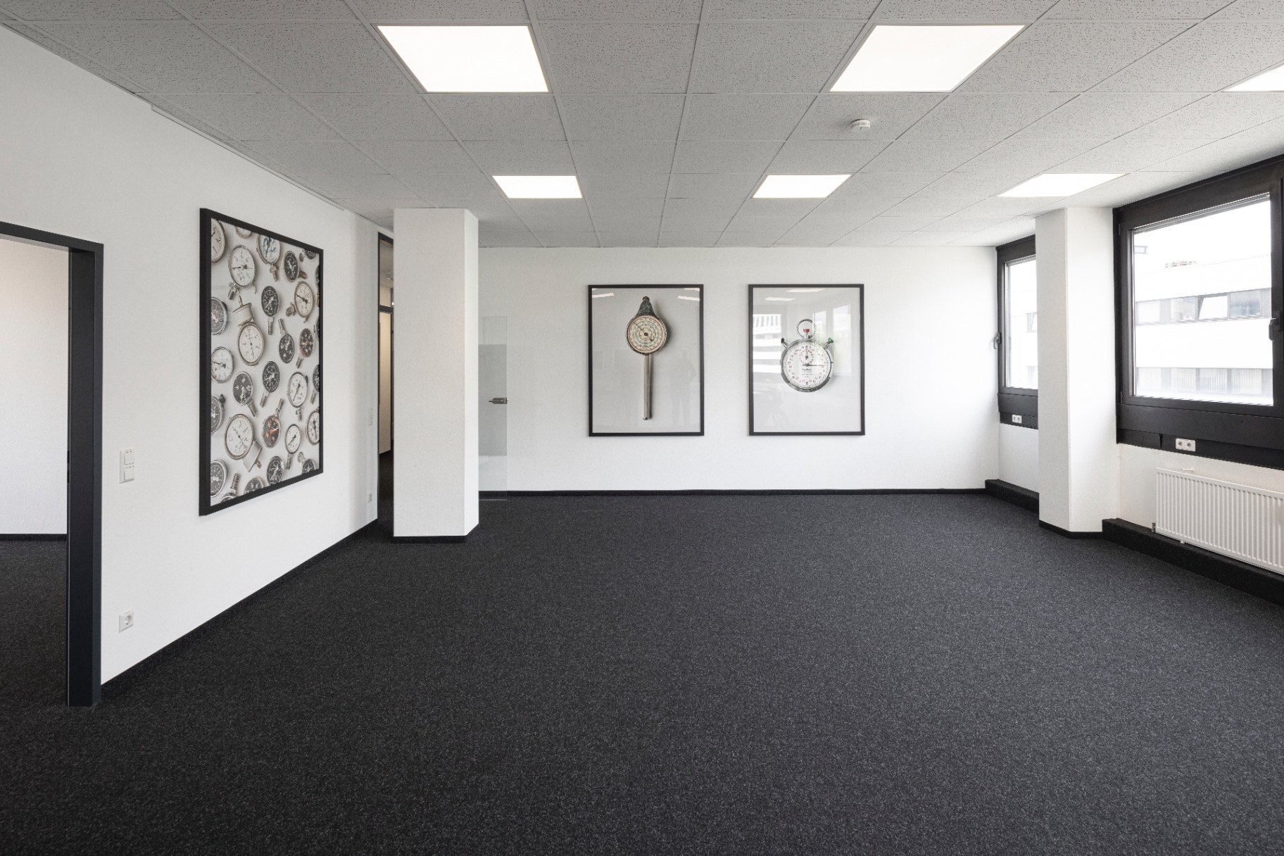 Corridor with three large framed photographs of vintage manometers and stopwatches