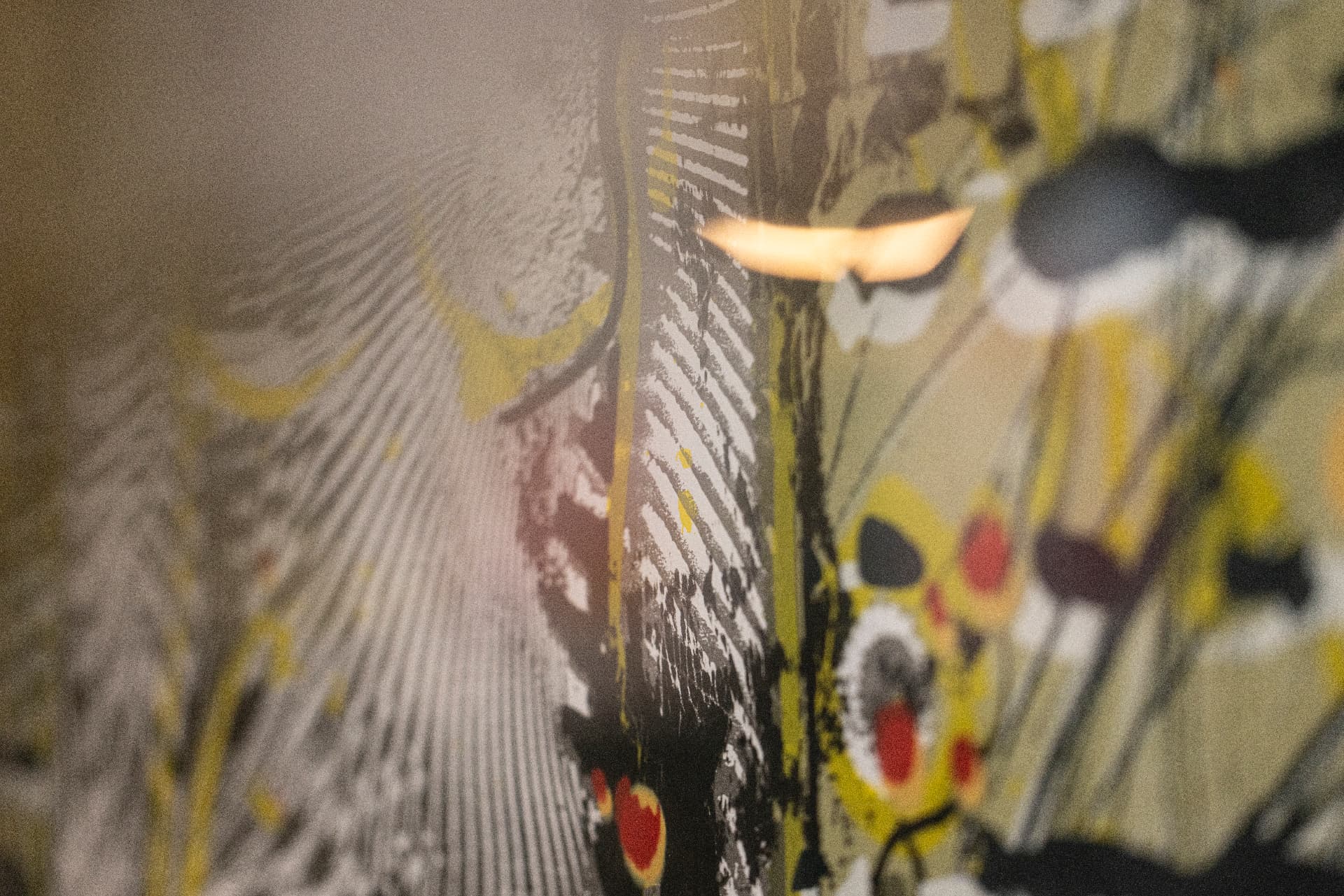Close-up detail of a painted wall with yellow, red and black marks
