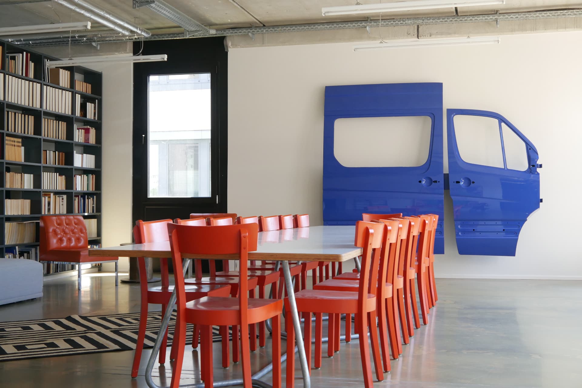 Founder lounge with yellow armchair, blue sofa and hammered-metal drum tables